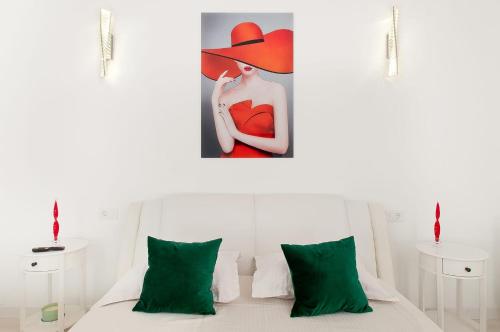 a bedroom with a bed with green pillows and a painting at Danube Residence in Galaţi