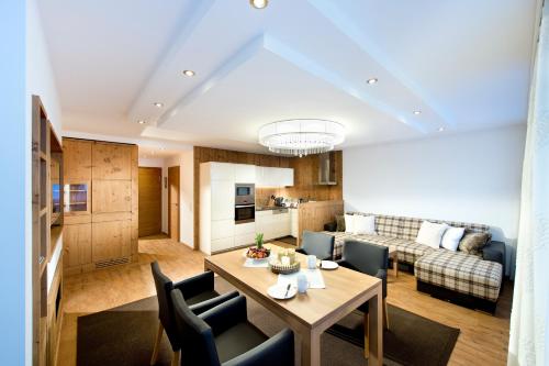 a kitchen and a living room with a table and chairs at Superior Hotel Post Ischgl in Ischgl