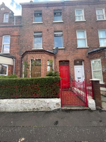 a red brick house with a red door at House in Antrim road in Belfast
