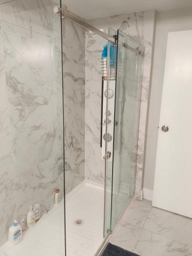 a shower with a glass door in a bathroom at Tom oker in Mississauga