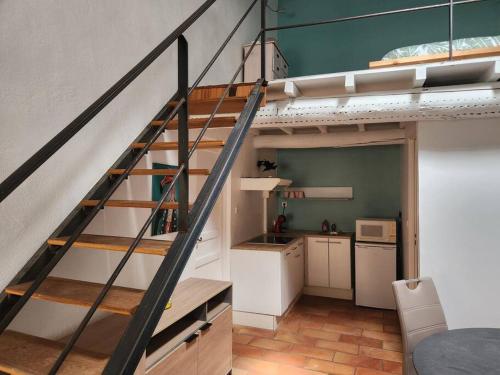 une chambre avec un escalier et une cuisine en mezzanine dans l'établissement Duplex en plein cœur d'Arles, à Arles