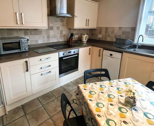 een keuken met een tafel met een tafelkleed erop bij Spaside Apartment in Scarborough