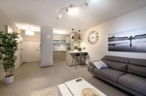 Il comprend un grand salon avec un canapé et une cuisine. dans l'établissement Appartement 2 pièces, à Cenon