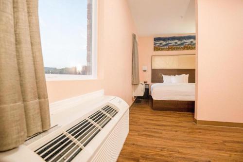 a hotel room with a bed and a window at Royal Inn & Suites in Adairsville