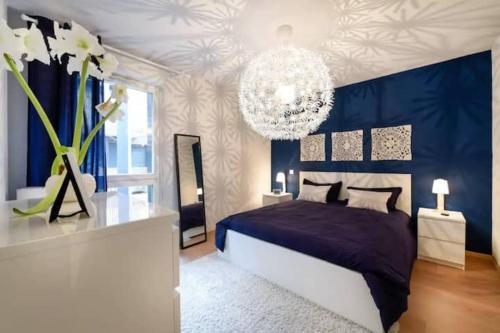 - une chambre avec un lit violet et un lustre dans l'établissement Appartement 2 pièces, à Cenon