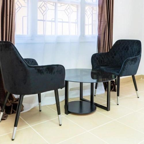 two chairs and a glass table in a room at Sofitel Executive 3 bedrooms own compound in Kisumu