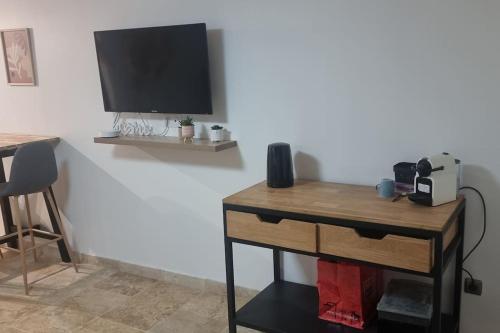 une table avec une télévision sur un mur et un bureau dans l'établissement studio 30 m2, à Villeneuve-le-Roi