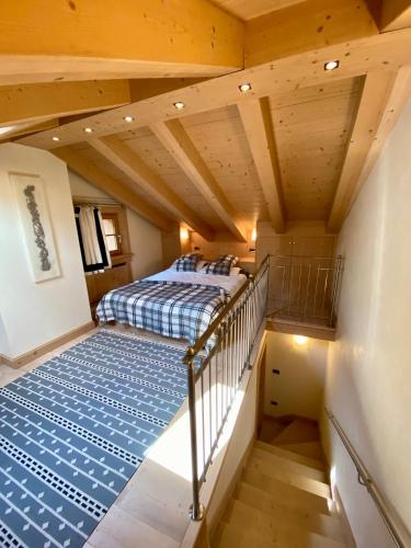 a attic bedroom with a bed and a staircase at Villa Zubiana in Cortina dʼAmpezzo