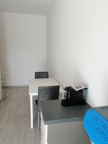 an office with a desk and chairs and a table at Angelana camere in Santa Maria degli Angeli