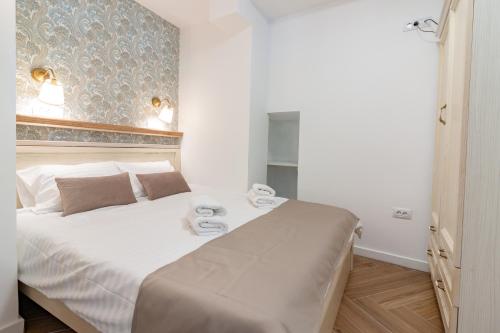 a bedroom with a white bed with towels on it at Villa Elena - Dolni Saraj in Ohrid