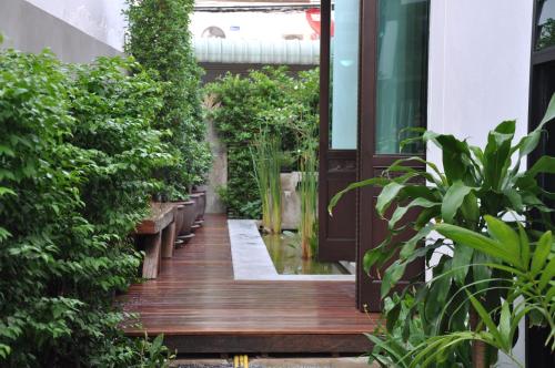 an open door to a garden with plants at Udee Bangkok Hostel in Bangkok