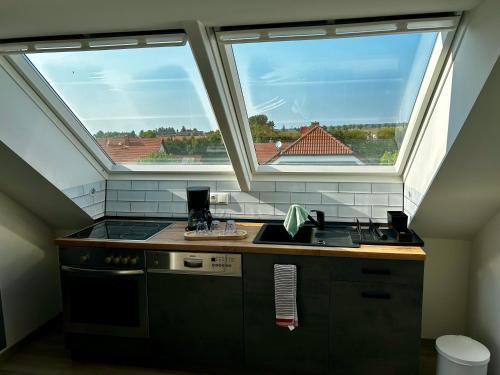 a kitchen with two windows and a stove and a sink at Ferienwohnung Molschleben in Molschleben