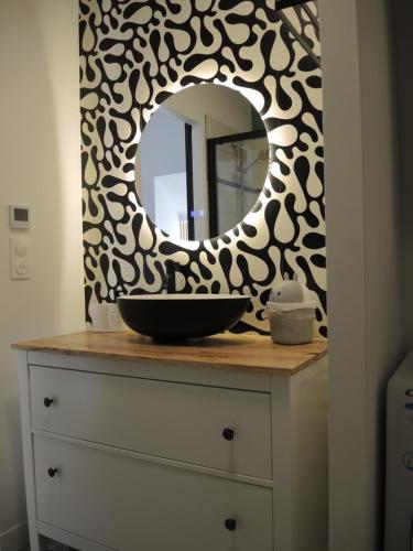 a bathroom with a sink and a mirror on a dresser at Maison Sorbier - Appartement 2 in Nevers