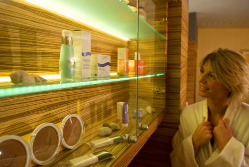 a woman standing in front of a shelf in a store at Business Resort Parkhotel Werth in Bolzano