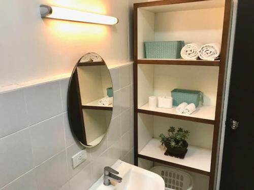 ein Badezimmer mit Spiegel und Waschbecken in der Unterkunft Mid-Century Modern Centrally Located Garden Oasis in Baguio City