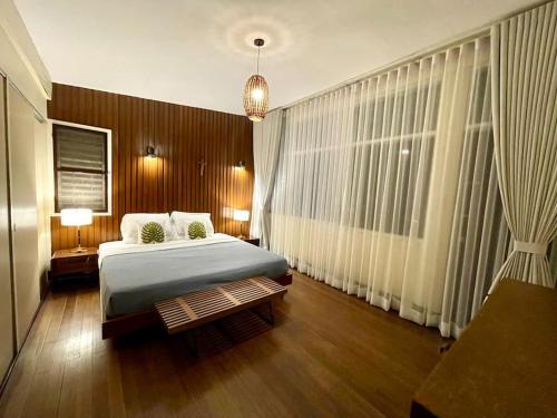 ein Schlafzimmer mit einem Bett und einem großen Fenster in der Unterkunft Mid-Century Modern Centrally Located Garden Oasis in Baguio City