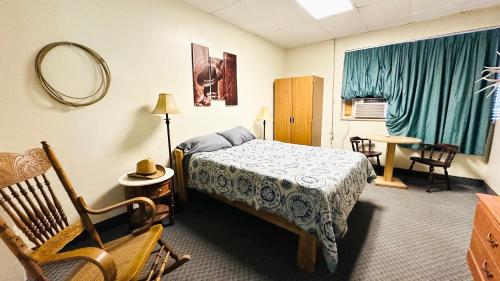 Un dormitorio con una cama, una silla y un espejo. en The Cowboy Bunkhouse, en Kanab