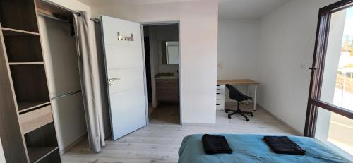 une petite chambre avec un lit et un bureau dans l'établissement Villa Caroline, à La Roche-sur-Yon