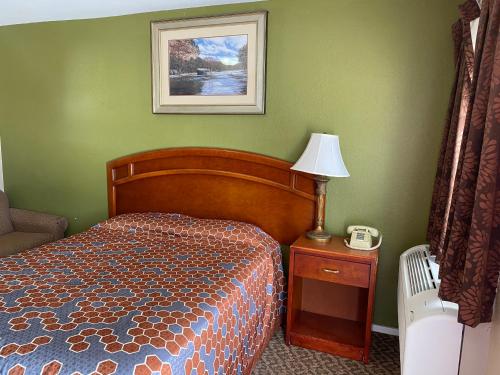 1 dormitorio con cama, lámpara y teléfono en American Star Inn, en Baird