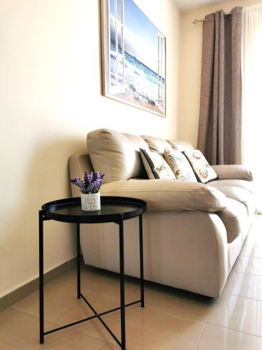 a living room with a couch and a table at Holiday apartment in Kyklades Complex with gym&pool in Paralimni