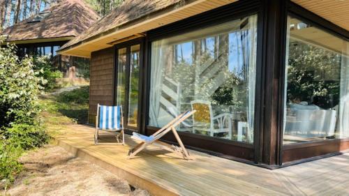 une terrasse couverte d'une maison avec une chaise et une fenêtre dans l'établissement 800m mer- La maison sous les pins-rénovée 2024, à Neufchâtel-Hardelot