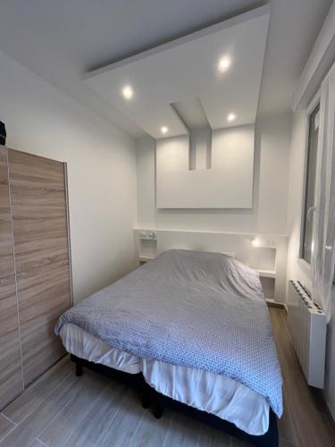 une chambre avec un lit et un miroir dans l'établissement La cour secrète, à Deauville