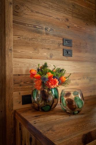 two vases sitting on a table with flowers in them at Asiago Sporting Hotel & Spa in Asiago