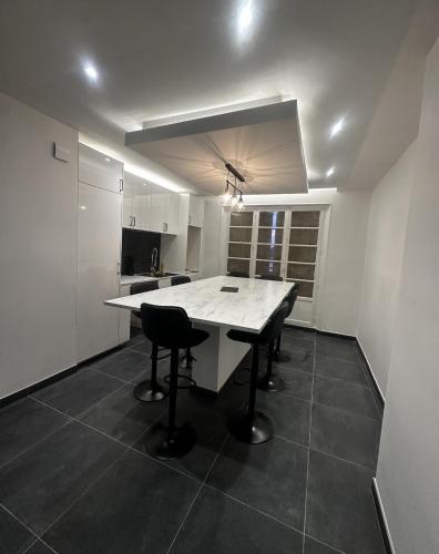 une cuisine blanche avec une table et des chaises dans l'établissement Chambre - Grenoble, Caserne de Bonne, à Grenoble