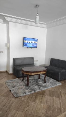 a living room with a coffee table and a couch at Les Appartements de la Place Atlas in Fès