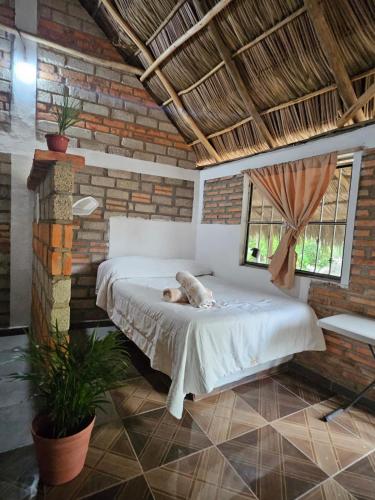 a bed in a room with a dog laying on it at Las Cabañas del Tio Lalo in Rincon de Guayabitos