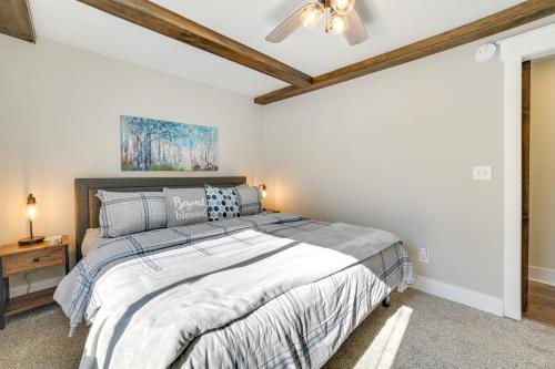 une chambre avec un lit et un ventilateur de plafond dans l'établissement Cozy Waterfront Hale Cottage on Long Lake!, à Lupton