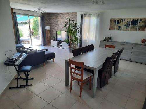 une cuisine et un salon avec une table et des chaises dans l'établissement L'Enchantée Piano'T - Maison à la campagne 6 pers, à Mailly-le-Camp