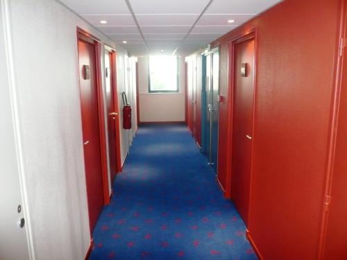 a long hallway with blue carpet in an office building at Hôtel Les Gens De Mer Dunkerque by Popinns in Dunkerque