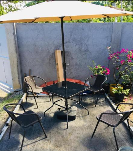 a table and chairs with an umbrella on a patio at Mommy Mia Bed and Breakfast in Dasag
