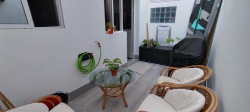 a living room with a glass table and chairs at Apart Laginha Tess & To in Mindelo