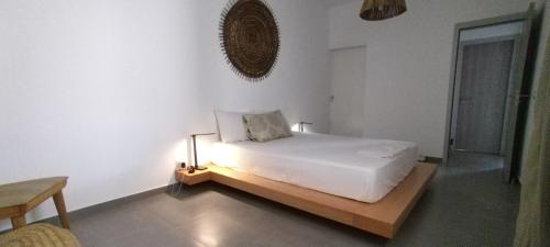 a white bedroom with a bed with a light on it at Apart Laginha Tess & To in Mindelo