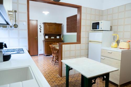 a kitchen with a refrigerator and a table in it at I Marchesi dell'Etna in Zafferana Etnea