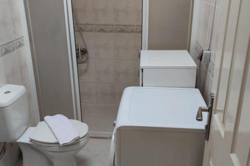 a white bathroom with a toilet and a shower at WoodenGate in Fethiye