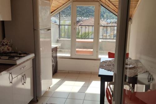 a kitchen with a refrigerator and a window and a counter at WoodenGate in Fethiye
