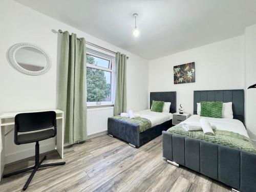 a bedroom with two beds and a desk and a window at Modern 3 Bedroom Home - Free Driveway Parking - 6 Guests - Upstairs Bathroom and Downstairs WC in Armthorpe