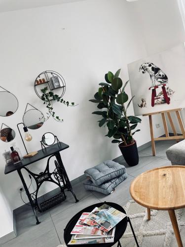 a living room with white walls and a table at Charmante maison à 20min de Lille in Oignies