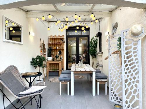 a patio with chairs and a table and a chandelier at Charmante maison à 20min de Lille in Oignies