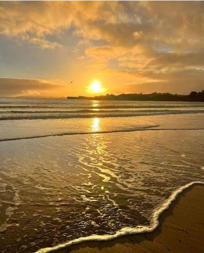a sunset on a beach with the ocean at The Lobster Pot in Tywardreath