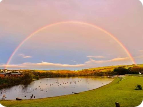 a rainbow over a pond with a group of people at The Lobster Pot in Tywardreath