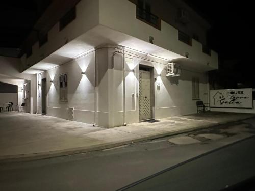 a white building with a door at night at House Torre Galea in Marina di Gioiosa Ionica
