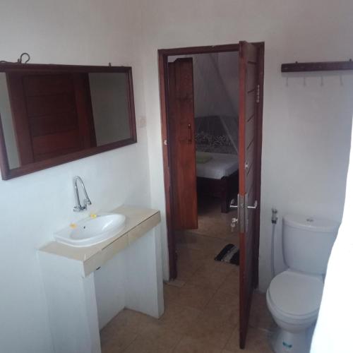 Un baño con lavabo, inodoro y espejo. en Pondok Jaje Bali, en Padangbai