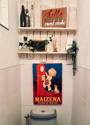 a sign on a wall above a toilet in a bathroom at Charmante maison à 20min de Lille in Oignies