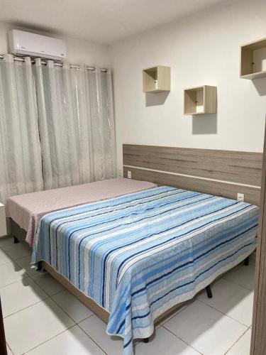 a bedroom with a bed with a striped blanket at Casa da Barra99 in Francês
