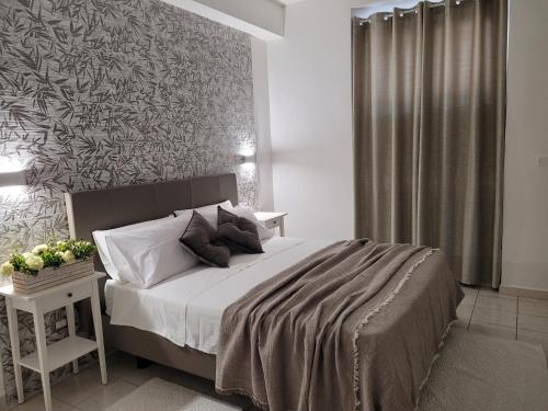 a bedroom with a large bed and a wall at House Torre Galea in Marina di Gioiosa Ionica