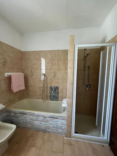 a bathroom with a tub and a toilet and a sink at PANORAMA,Cremia-casa LUISA in Cremia